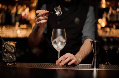 Barmen sakallı buz cam koyar.