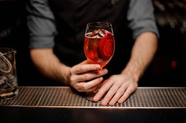Kırmızı kokteyl cam barmenler elinde