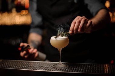 Barmen biberiye alkol hafif kahverengi kokteyl ekler.