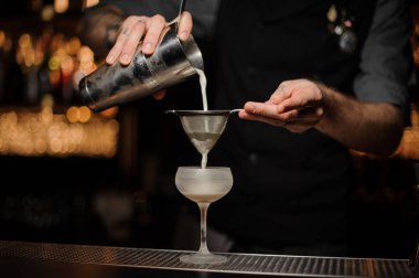 Barmen kokteyl ekleyerek ekşi karışımı cam dökülen.