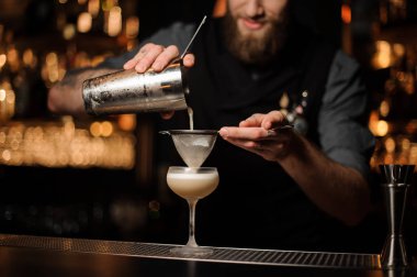 Barmen kokteyl ekleyerek ekşi karışımı cam dökülen.