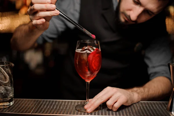 Barman masculino derramando coquetel vermelho em vidro — Fotografia de Stock