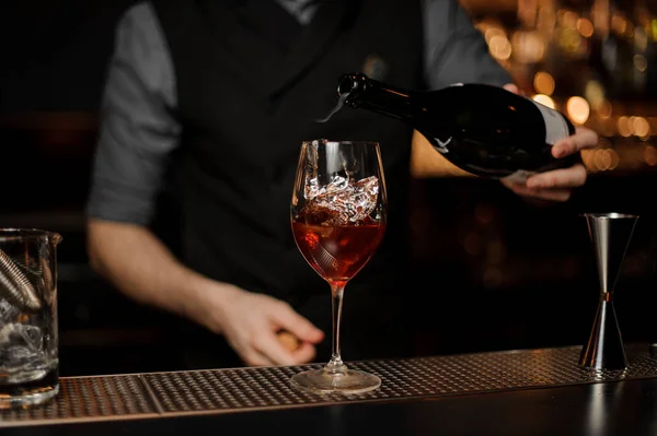 Barman voegt mousserende wijn in cocktail op een balk teller — Stockfoto