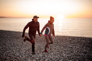 Plajda çalışan romantik çift eller tutarak