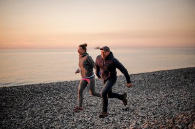 Sahilde çalışan mutlu çift el tutarak