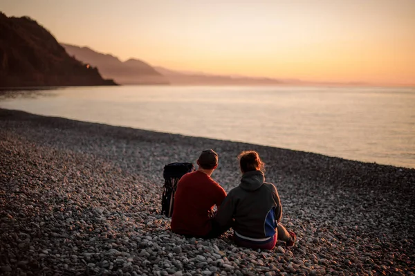 Joven pareja feliz romántico sentado en la playa —  Fotos de Stock