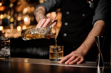 Barmen kokteyl ile ölçüm cam fincan bir alkol dökümü