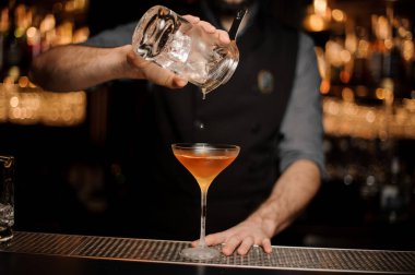 Barmen kokteyl cam için süzgeç yoluyla ölçüm bardaktan bir alkollü içecek dökme