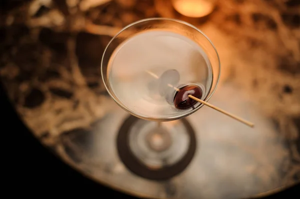 View from above cocktail in the ice cold glass decorated with a berries on the skewer standing on the marble table — Stock Photo, Image