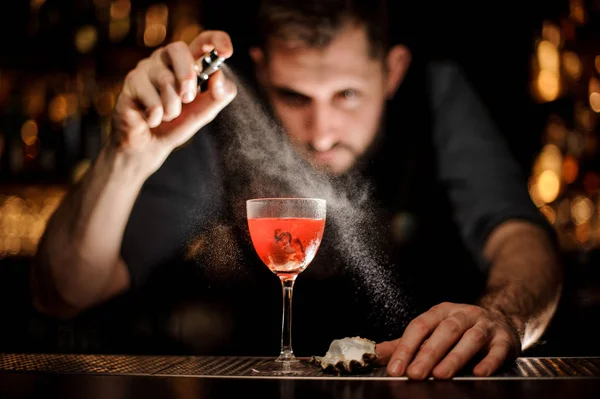 Barista professionista che spruzza sul delizioso cocktail rosso trasparente nel bicchiere — Foto Stock