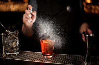 Bir büyük buz küpü ile kokteyl cam püskürtme erkek barmen