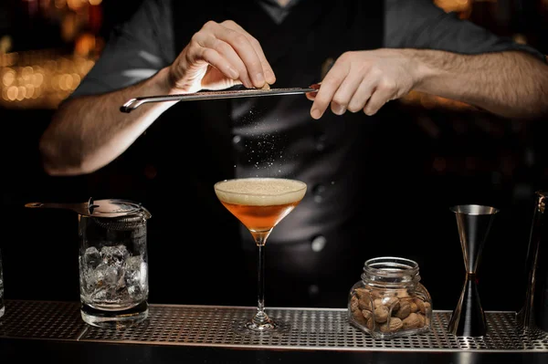 Barman dodając do koktajlu w szklance tartą gałkę muszkatołową — Zdjęcie stockowe