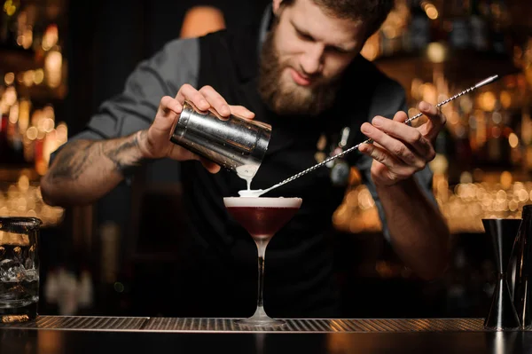 Barista versando una panna montata al bicchiere da cocktail sul cucchiaio — Foto Stock