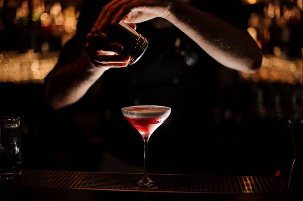 Barkeeper fügt einem Cocktail mit Schlagsahne ein rotes Pulver hinzu — Stockfoto