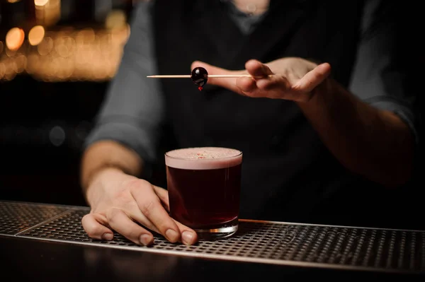Coctel decorado camarero profesional con una baya roja en un pincho — Foto de Stock