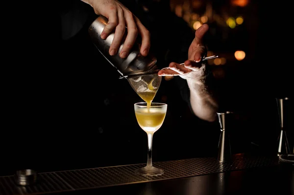 Barman sirviendo un delicioso cóctel del agitador de acero a través del tamiz — Foto de Stock