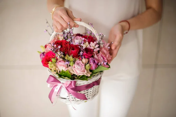 Девушка держит корзину нежных розовых и красных цветов — стоковое фото