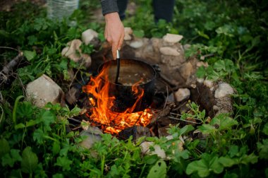 Kamp ateşi üzerinde Pan erkek pişirme gıda yakın çekim