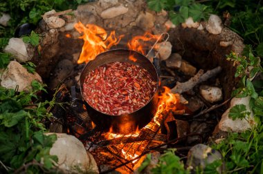 Kamp ateşi üzerinde bir tavada güveç yakın çekim