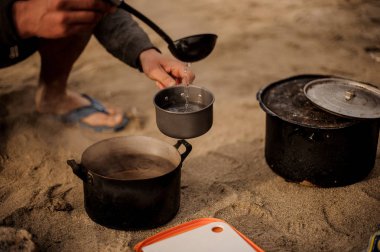 Adam küçük bir tavada çorba dökülen