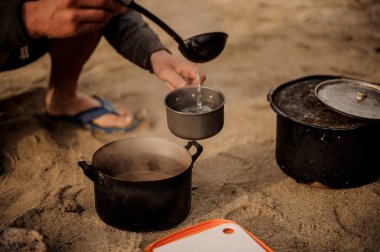 Adam metal tavada çorba dökülen