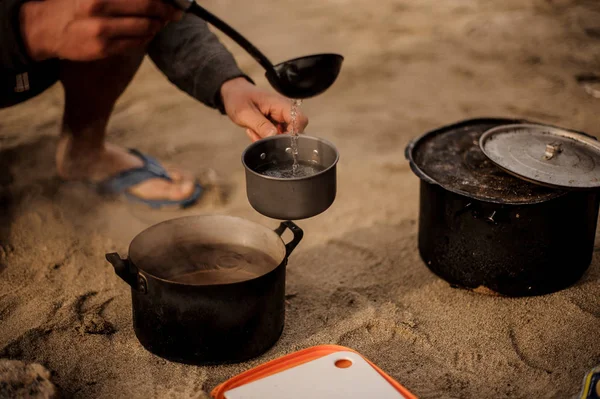 Adam küçük bir tavada çorba dökülen