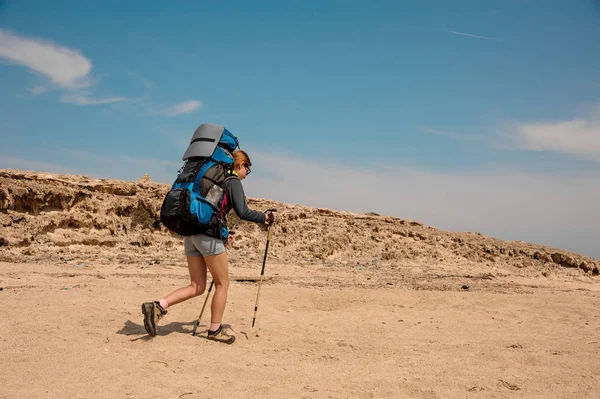 Young woman hiking with sticks in desert