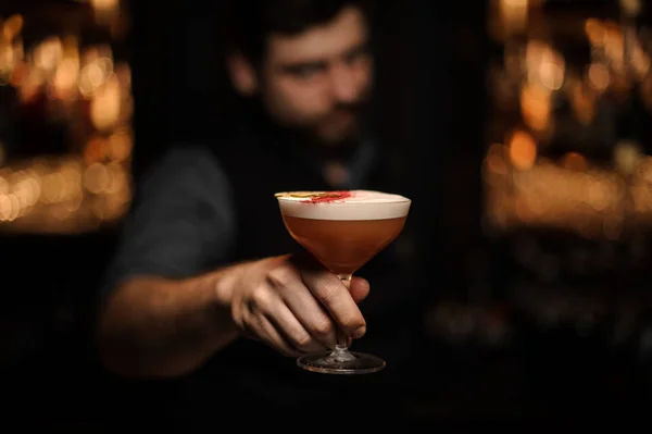 Barman houdt alcohol cocktail in zijn handen — Stockfoto