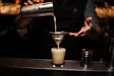 Elek ve shaker kullanarak kokteyl döken barmen yakın çekim