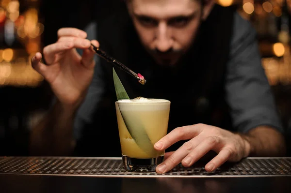 Barman schenkt cocktail met rode bes met behulp van een tang — Stockfoto