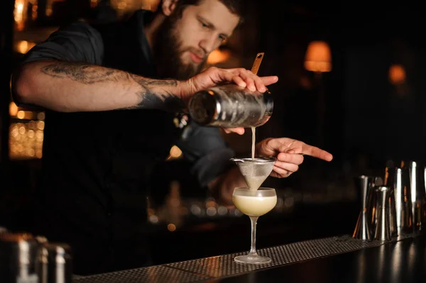 Barista aggiunge mix acido in cocktail alcolici utilizzando shaker e setaccio — Foto Stock