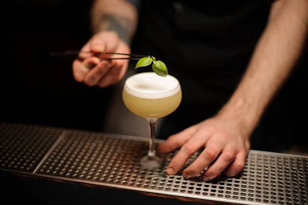 Nahaufnahme eines Barkeepers bei der Zubereitung eines Cocktails mit einer Pinzette — Stockfoto
