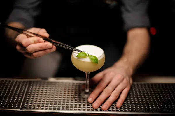 Närbild av en bartender hälla cocktail med pincoppar — Stockfoto