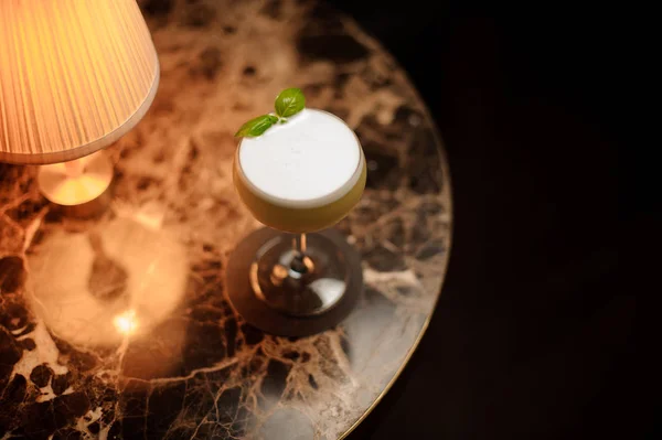 Cocktail alcolico alla menta su un tavolo con lampada — Foto Stock