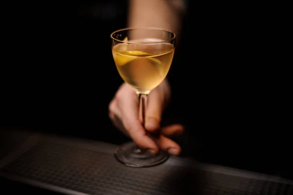Close-up dari koktail alkohol dengan kulit lemon di tangan bartender — Stok Foto