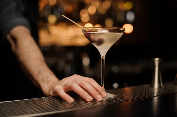 Gros plan d'un cocktail à base d'alcool avec des olives sous la main du barman — Photo