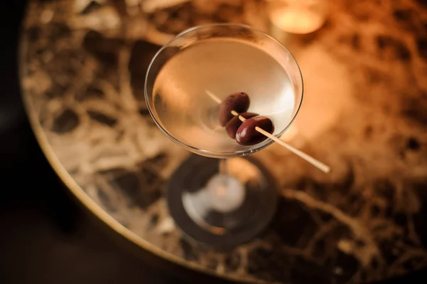 Primo piano di un cocktail alcolico con olive sul tavolo — Foto Stock