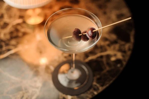 Close-up of alcohol cocktail with olives on the table — Stock Photo, Image