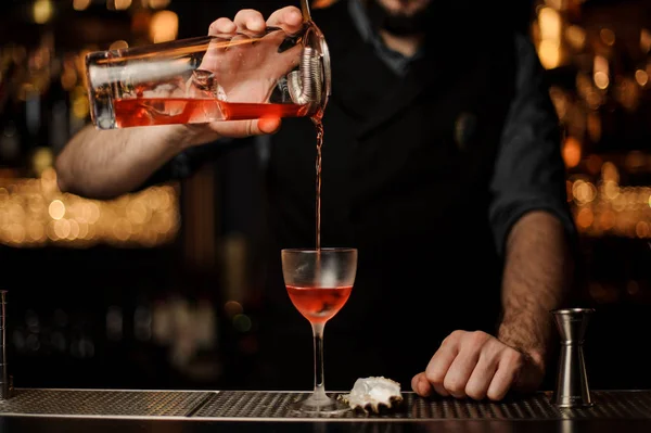 Cantinero vierte un cóctel de alcohol usando frasco con tamiz — Foto de Stock