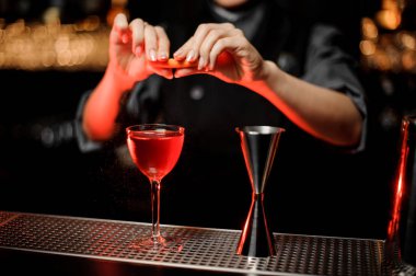 Barmen alkol kokteylturuncu parça sıkıyor