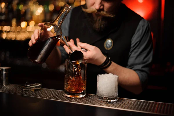 Cantinero sirviendo un cóctel de alcohol con jigger — Foto de Stock