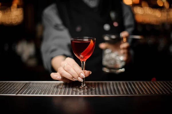 Primo piano del barista che tiene cocktail alcolici e bicchiere con colino — Foto Stock