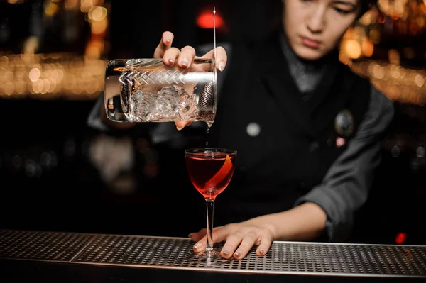 Bartender making alcohol cocktail using glass with strainer — Stock Photo, Image