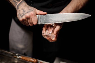 Barmenin bıçakla buz kesmesinin yakın çekimi