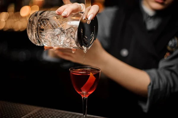 Primo piano del barista femminile che prepara cocktail alcolici usando un colino — Foto Stock