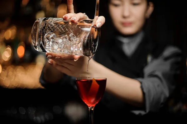 Barkeeperin gießt Alkohol-Cocktail mit Sieb — Stockfoto
