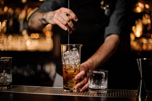 Barista maschio mescolando cocktail alcolici con cucchiaio da bar — Foto Stock