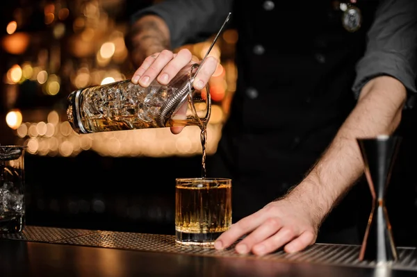 Il barista versa un cocktail alcolico aggiungendo whisky — Foto Stock