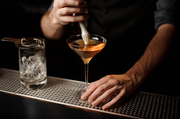 Barman nalewanie alkoholu koktajl dodając pianki — Zdjęcie stockowe