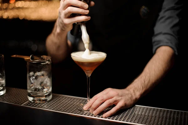 Il barista versa un cocktail alcolico aggiungendo schiuma — Foto Stock